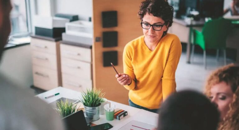 Mulher em um escritório possivelmente discutindo um Procedimento Operacional Padrão POP com a equipe