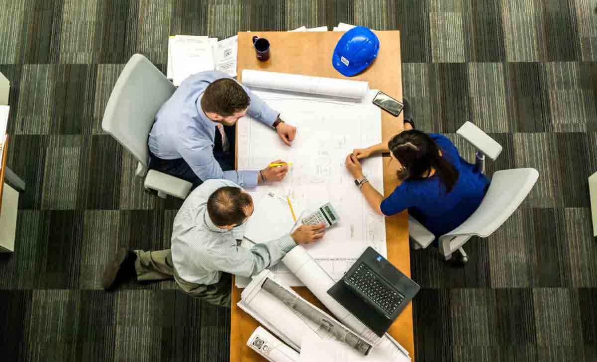 Profissionais realizando a Gestão da Produção Industrial ao redor da mesa