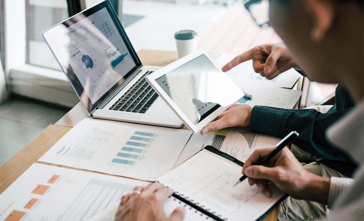 Profissionais olhando gráficos para realizar uma boa gestão de operações