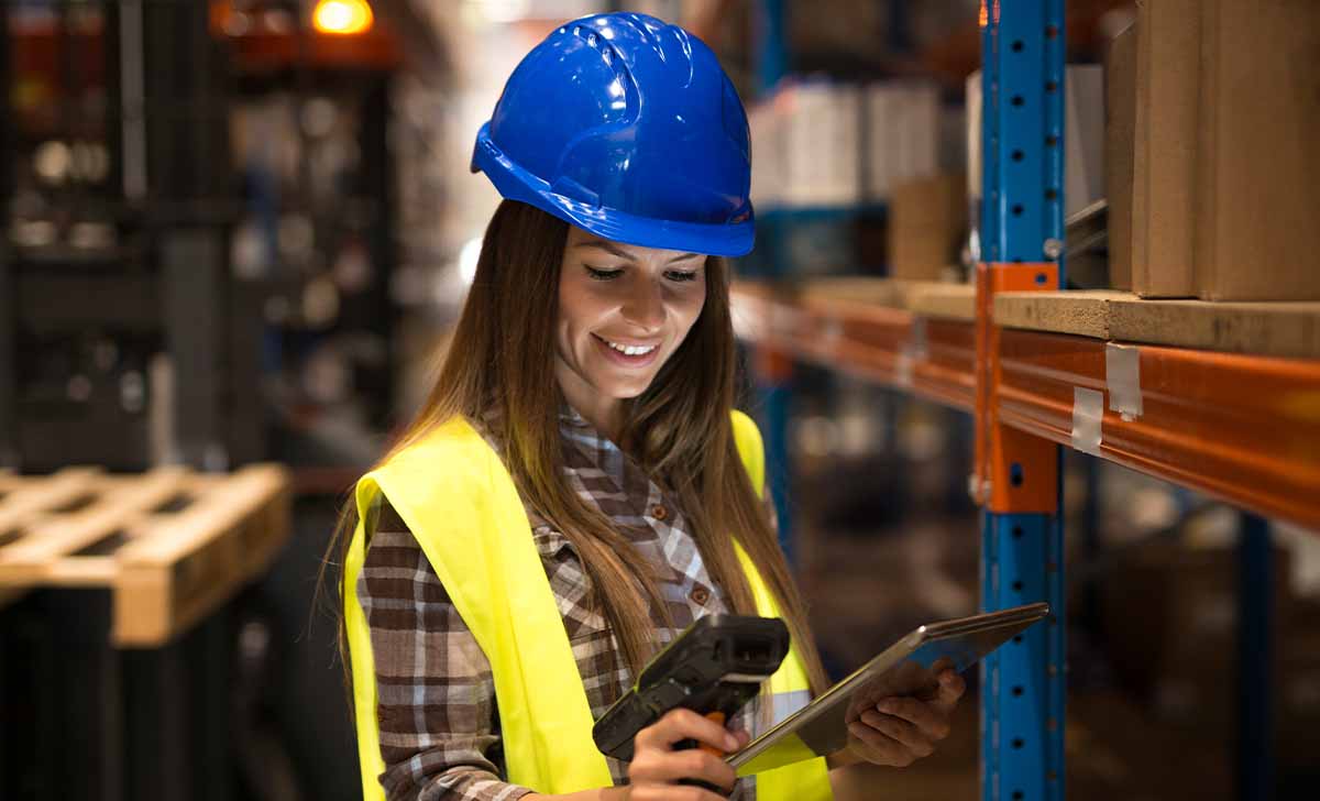 mulher fazendo manutenção industrial com um tablet