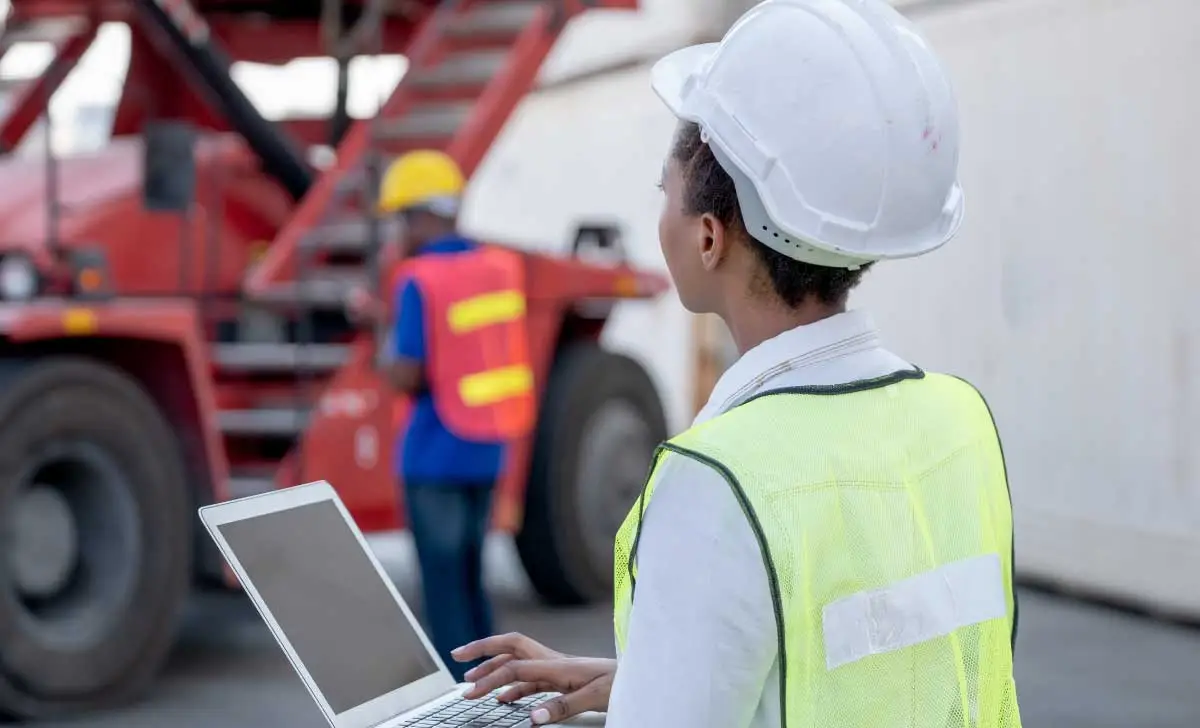 Mulher profissional do SESMT realizando auditoria em obra, conforme NR 4.
