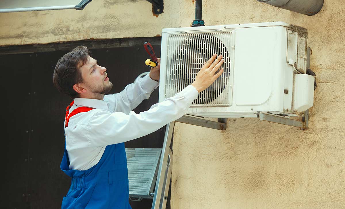 Técnico realizando limpeza de ar-condicionado seguindo o PMOC