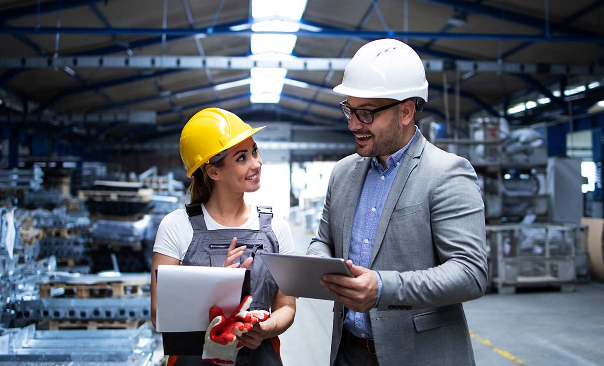 homem e mulher conversando sobre os tipos de tipos de manutenção industrial