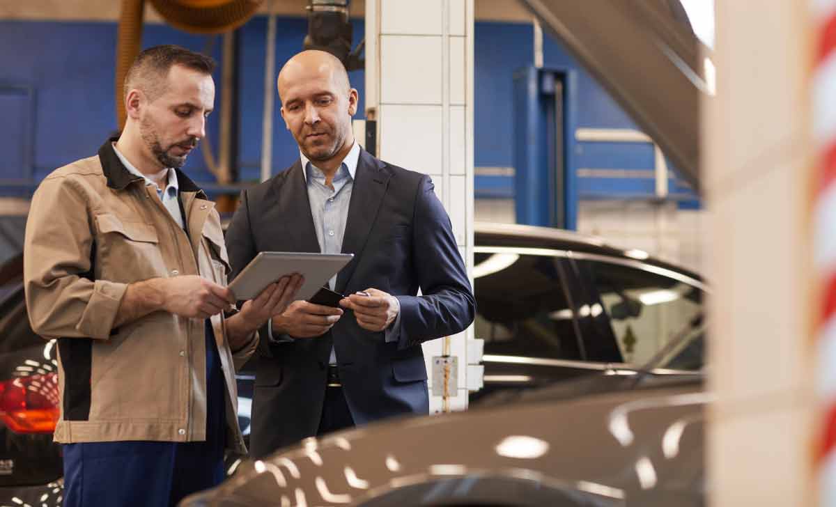 Dois homens realizando a vistoria veicular